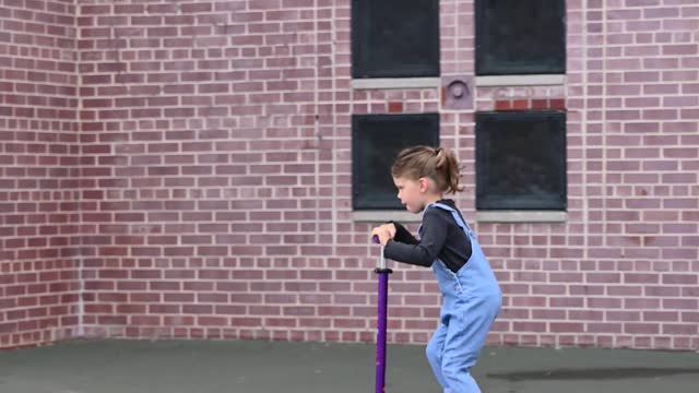 Girl on her kid scooter playing outdoors