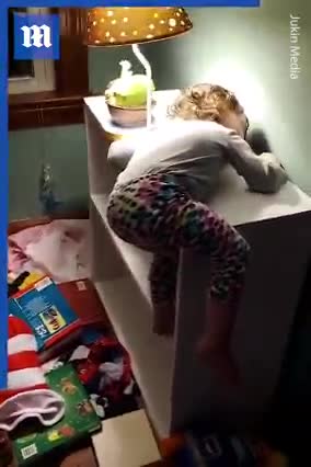 Toddler falls asleep on top of bookshelf