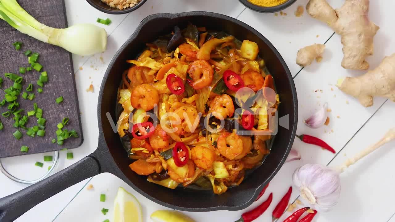 Fresh fried noodles with vegetables with shrimps served in black iron pan With various ingredients