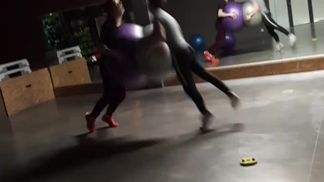 Two guys run at each other with exercise ball, faces smash into each other