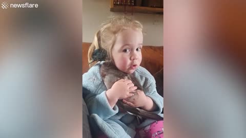 Adorable cute Baby cuddling her pet duck