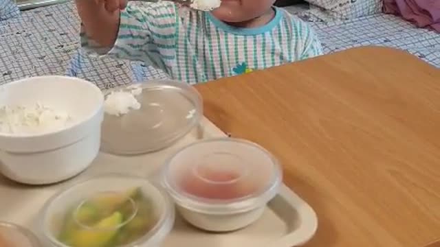 This is a video of a baby eating deliciously on his own.