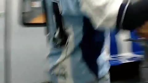 Pt. 2 man dances on a pole in subway train, wearing blue maradona shirt