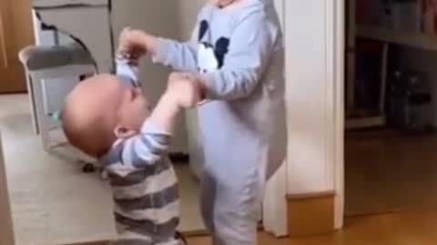 Brother helps the other to learn to walk, very beautiful
