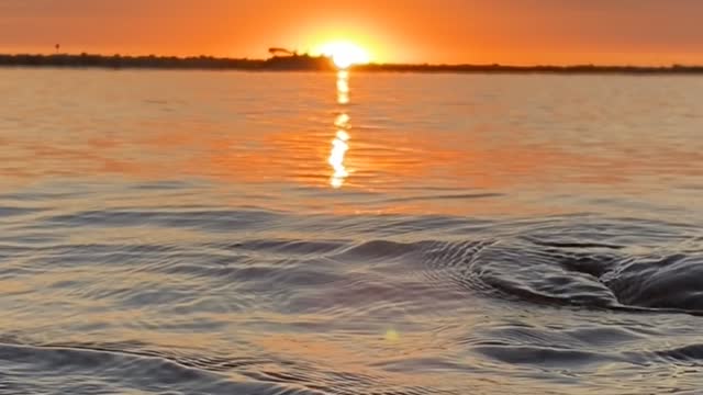 Pontoon passes by sunset