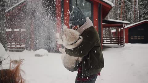 Dog Are Playing With Ice Snow With Beautiful Couple.