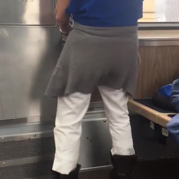 Woman blue shirt standing up and down holding onto pole