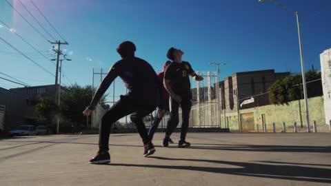 Three men playing soccer in concrete field