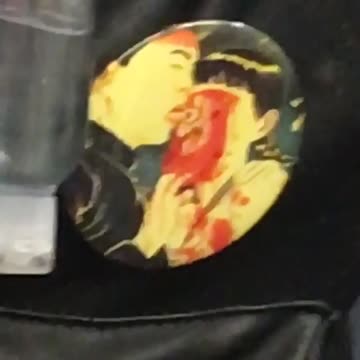Backpack button with man licking eye