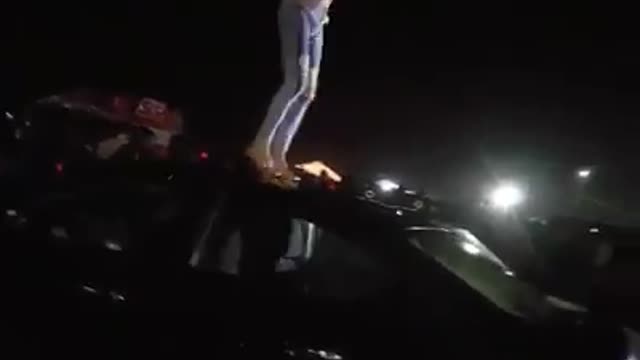 Shirtless ripped jeans guy dancing on top of black car slips face plant