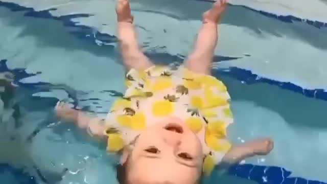 baby doing swimming in a unique moment