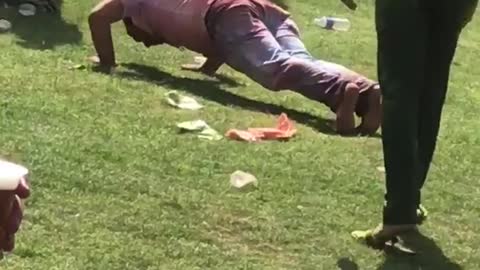 Man at holi festival does push ups in field