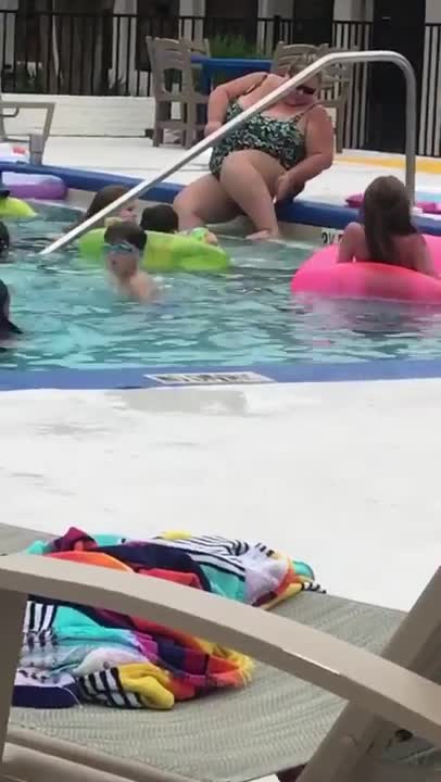 Woman shaving her legs at a swimming pool