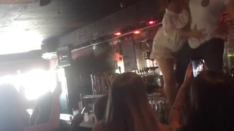 Music girls white shirt dancing on table almost falling