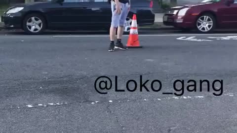 Guy in black shirt puts orange cone on street