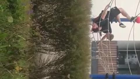 Guy flips over in playground net, does scorpion