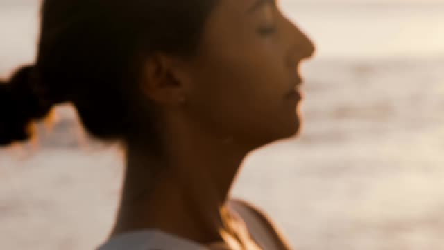 Woman Meditating On The Beach
