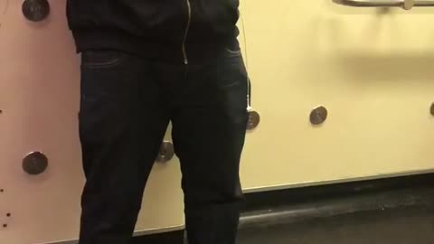 Guy listens to music out loud on train when he has earphones in his pocket