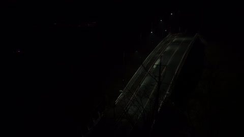 Car passing by the bridge late at night