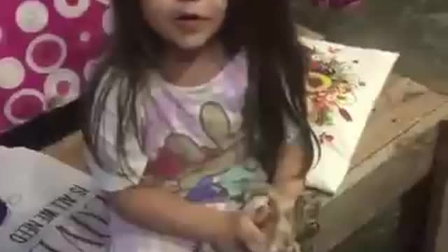 niña de 5 años juega con un gran zapo