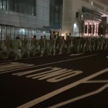 Troops march in front of the US capitol building.