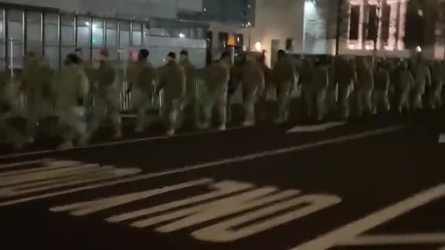 Troops march in front of the US capitol building.