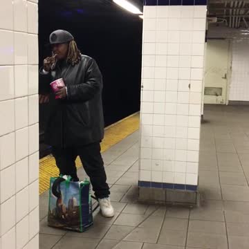 Guy eats out of tub with spoon in subway