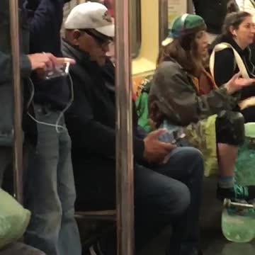 Girl with skateboard dancing with hands subway sitting down