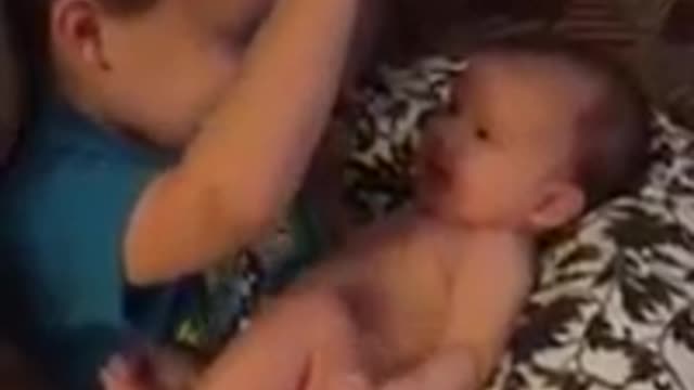 Toddler sings to his baby sister