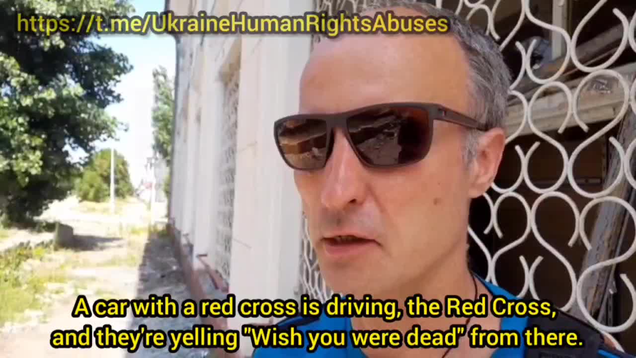 Ukrainian Nazis shouted curses at people, driving in a Red Cross car.