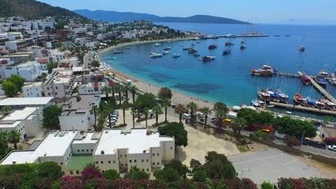 Aerial view of house, beach and a marina in a blue ocean