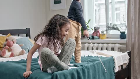 Kids Playing Catch The Bait With Their Cat