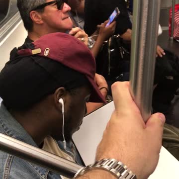 Man in glasses picks at beard hair