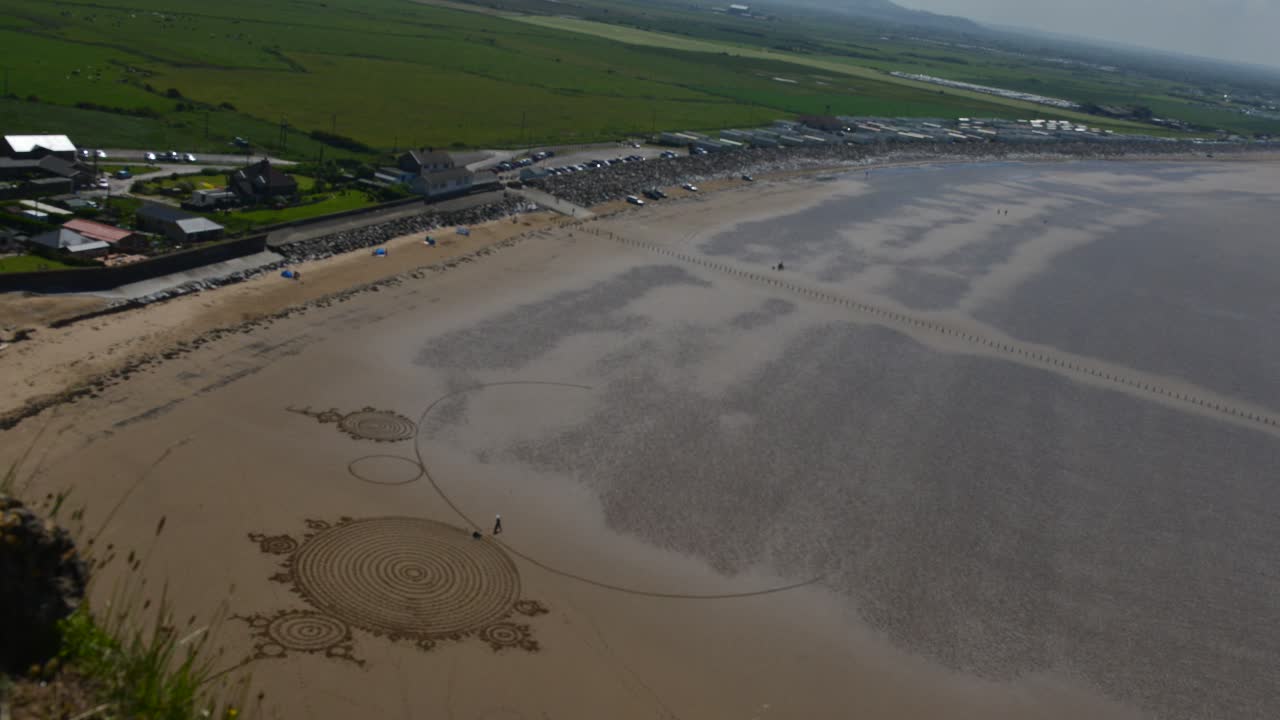 Sand artist uses entire beach to create incredible drawing