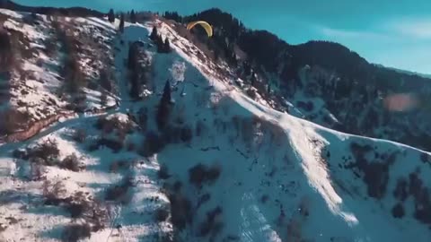 Paragliding above the snowy mountains