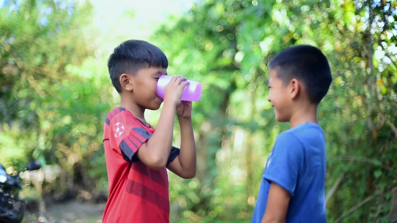 Little Boy Gives Friend A Drink of Water