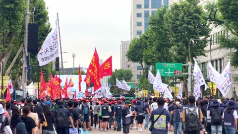 Workers march in protest with flags in Seoul, South Korea, July 15, 2023