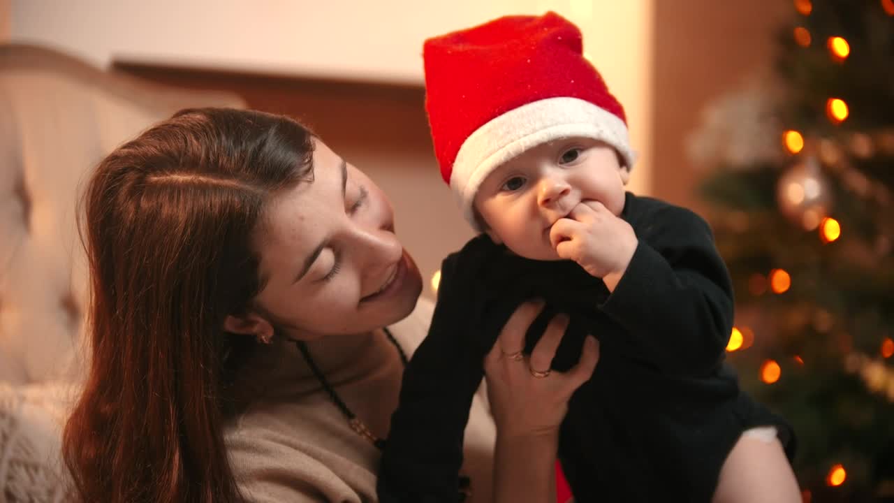 Happy mom holding her baby at Christmas