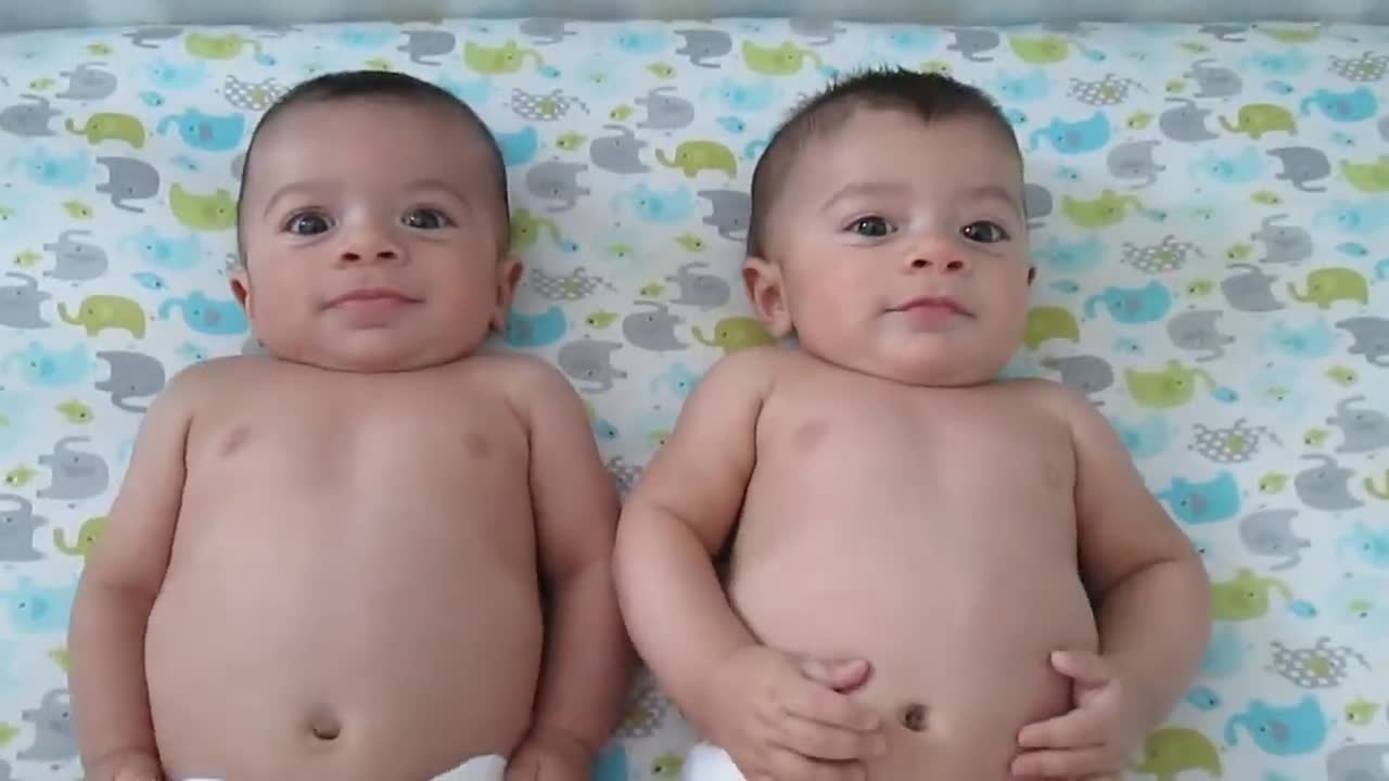 Cute twin babies tickled and laughing