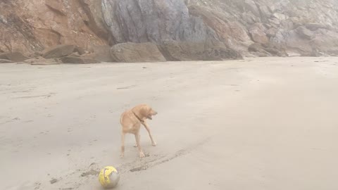 Sam and Shaun play football on Little Perhaver Beach near Gorran Haven Cornwall