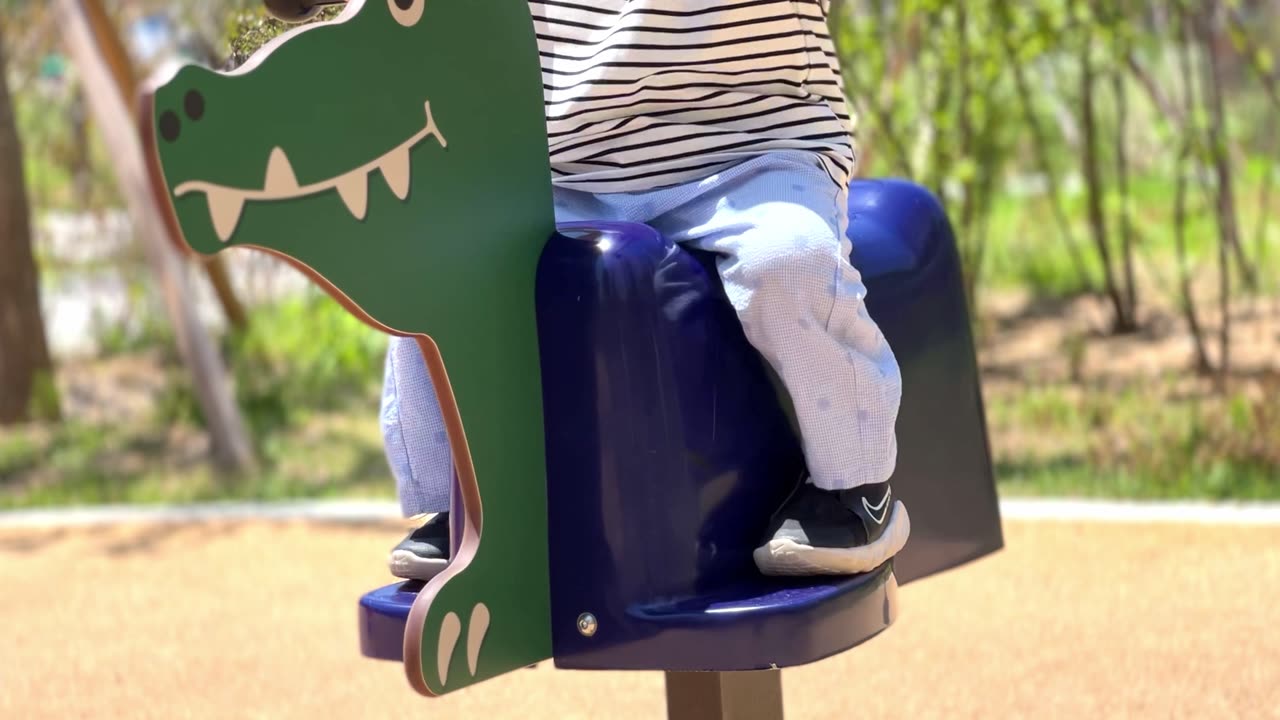 a child on a small ride in a playground