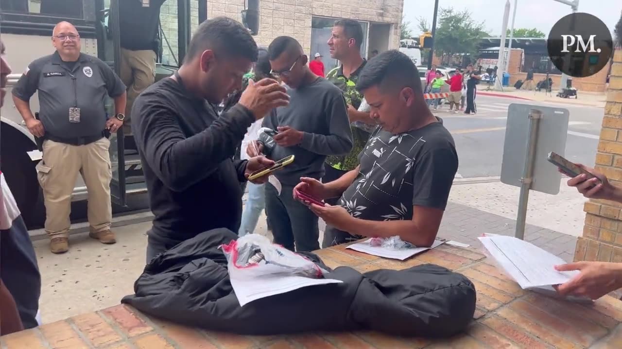 Brownsville, TX: Migrants open their DHS packets and use their government issued cell phones