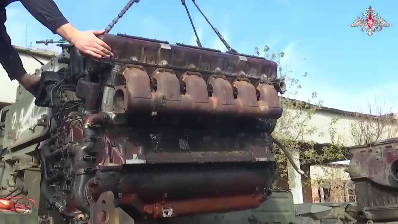 servicemen maintain weapons and vehicles in the field