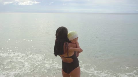 Mom with a daughter walking on the sandy beach