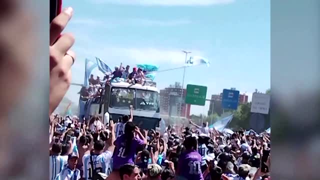 Fans jump onto Argentina players' bus, one falls