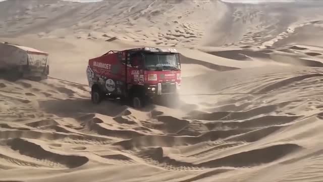 Two dakar trucks help one dakar truck