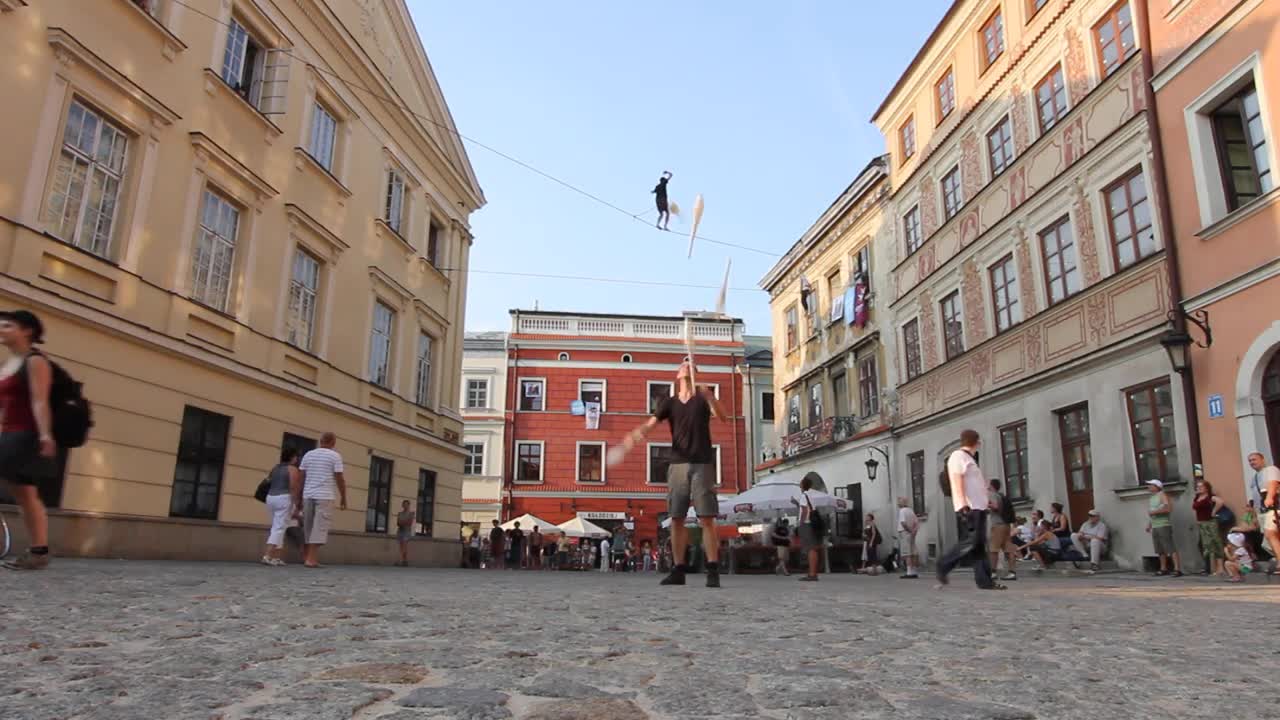 Guy Juggles 5 Clubs While Another Walks on a Slackline