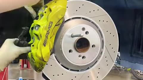 A mechanic replaces a new car brake disc