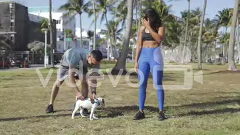 Sporty couple with dog in the park