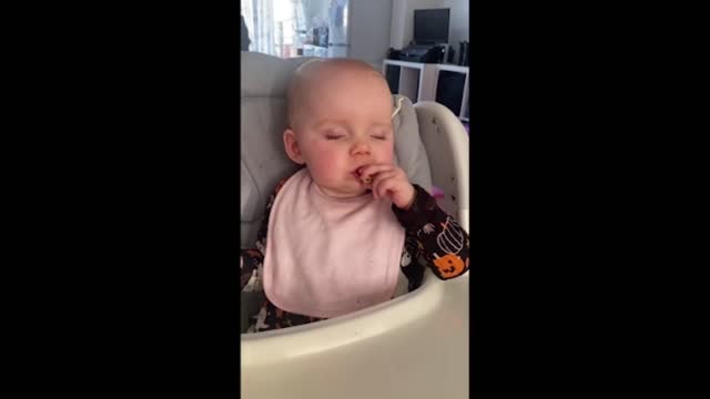 Tired baby goes into sleep mode while eating snack